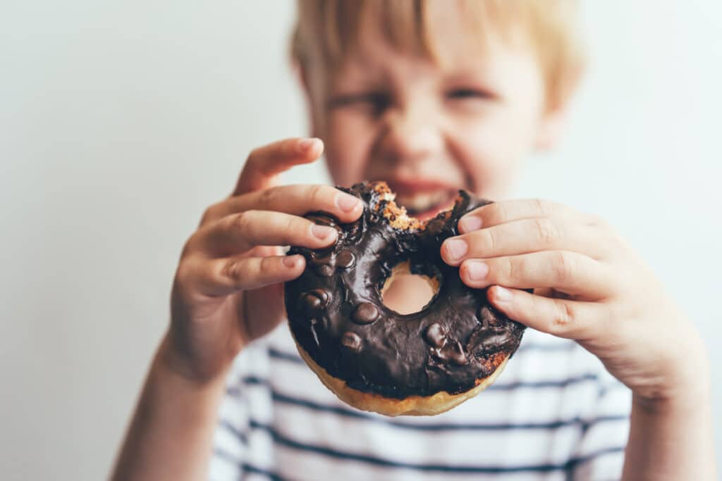 closeup of a bitten chocolate donut in the hands o 2021 08 30 07 47 29 utc