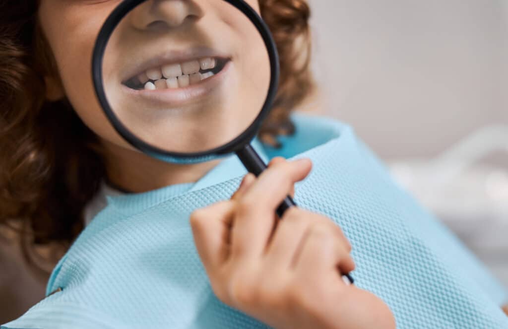 kid in a dental clinic playing with a magnifying g 2021 09 03 21 03 04 utc scaled e1698663161883