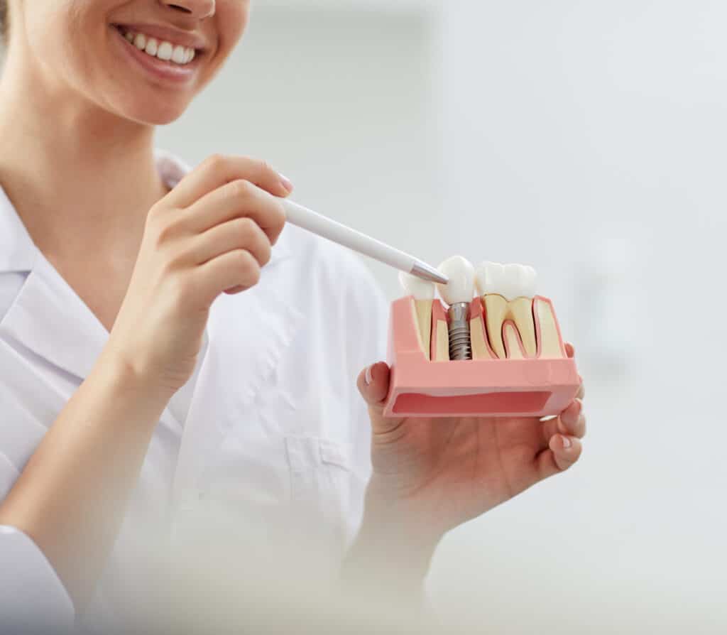 smiling dentist explaining tooth implantation 2021 09 24 03 53 51 utc scaled e1698687785586